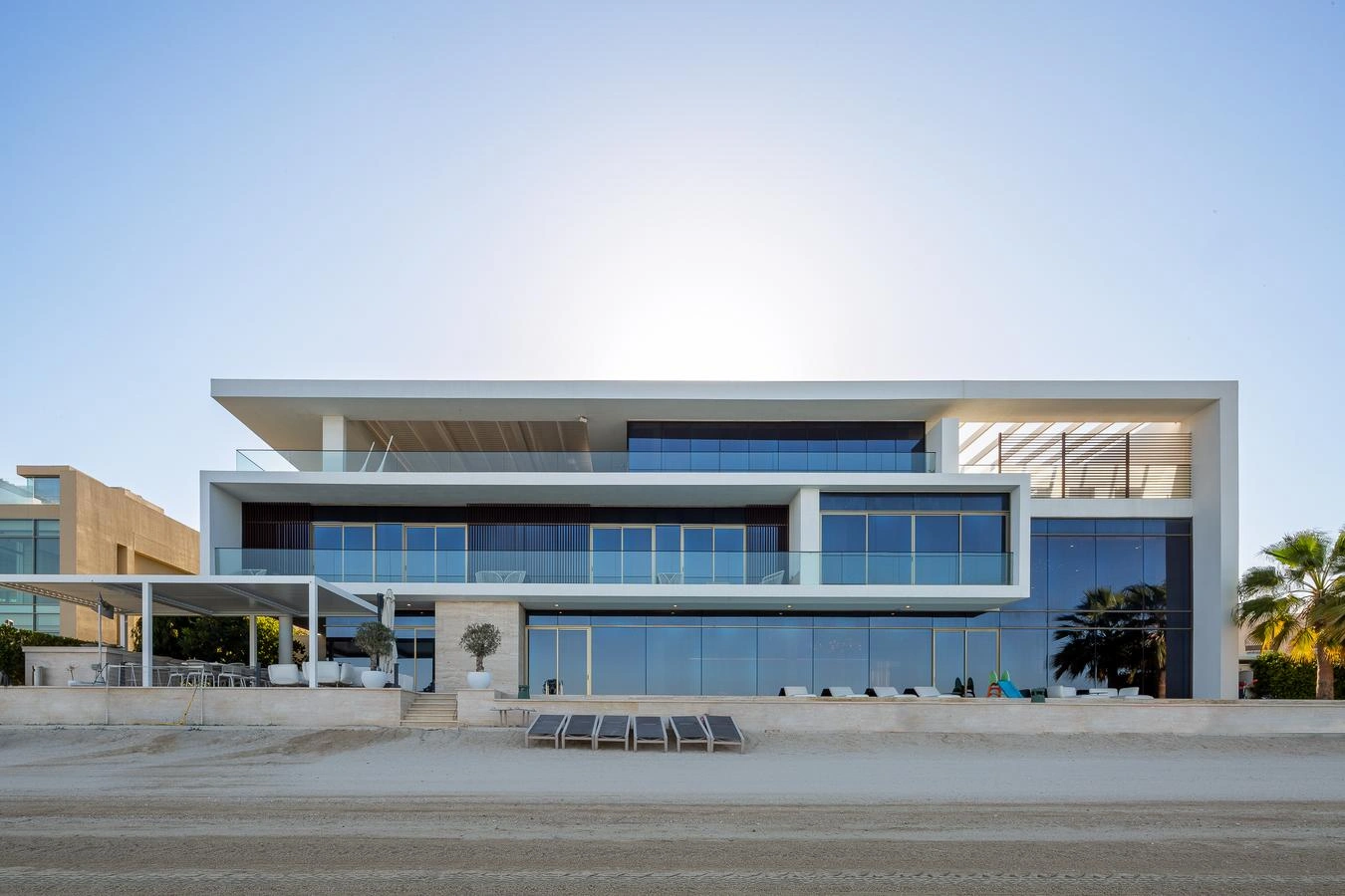 Luxurious living room with modular sofas, coffee table, ornate chandelier, and floor-to-ceiling windows