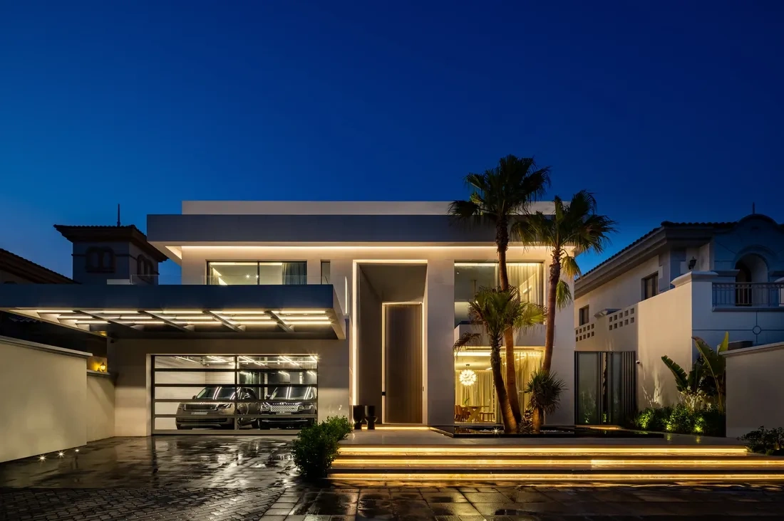 Elegant living room design with a marble coffee table, winged figure art on a wooden wall, and a chandelier