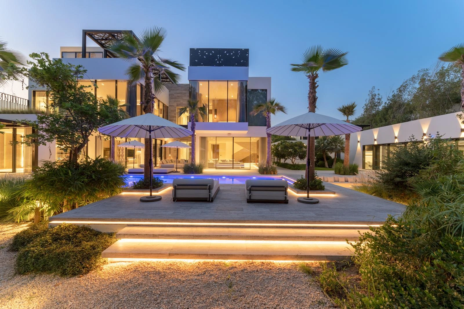Modern living room with L-shaped sofa, marble-textured wall, and floor-to-ceiling windows