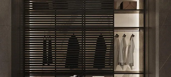 Modern villa entrance with minimalist architecture large glass panels, natural stone cladding, and a narrow water feature flanking a concrete pathway and a bonsai tree