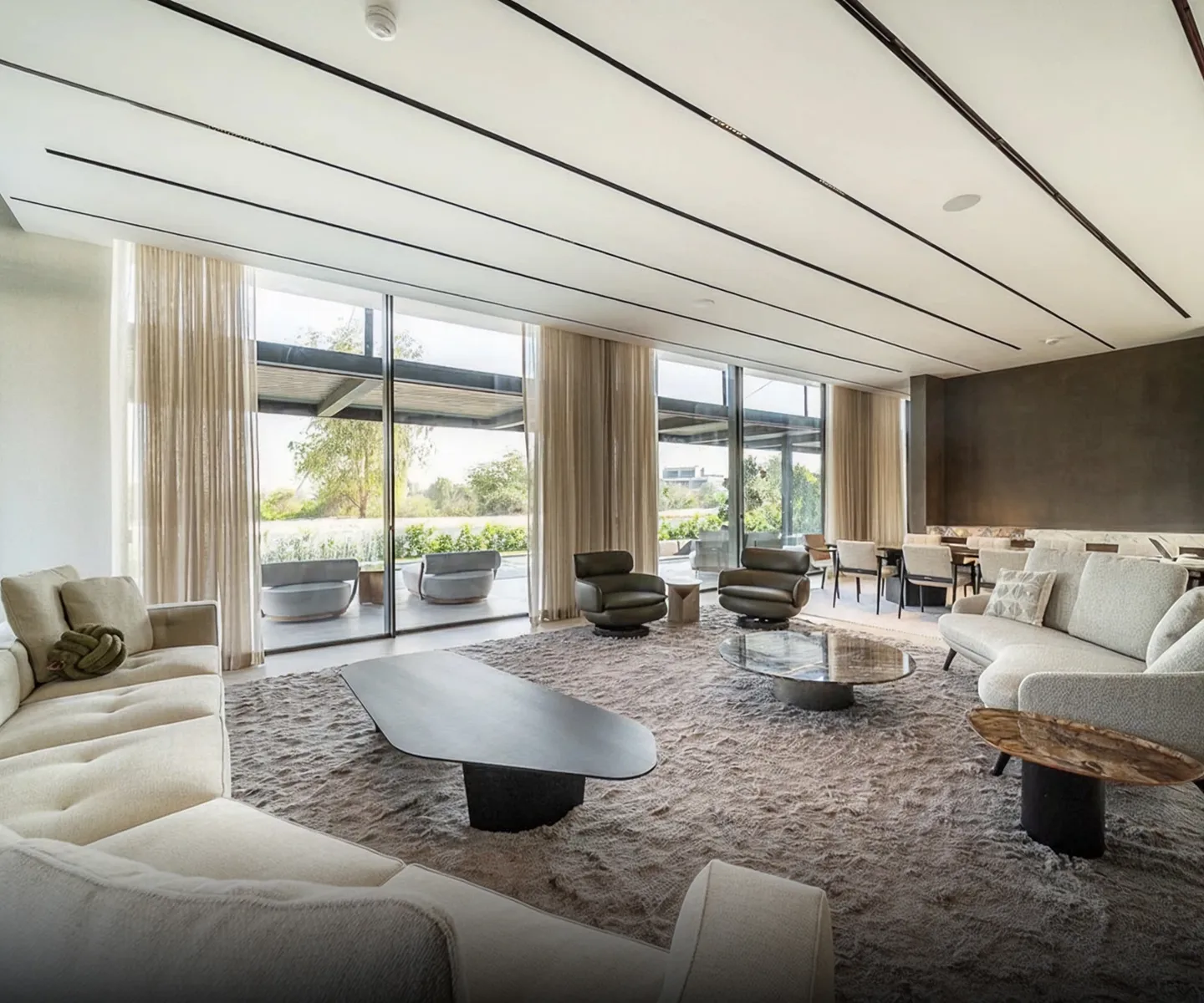 Modern living room interior design with a floating glass staircase in Dubai.