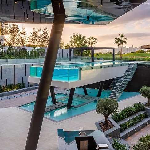 Glass-walled swimming pool integrated with contemporary interior design.