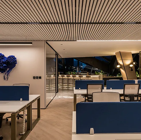 Open-plan office interior design featuring bespoke sleek desks and custom ceiling in Dubai. 