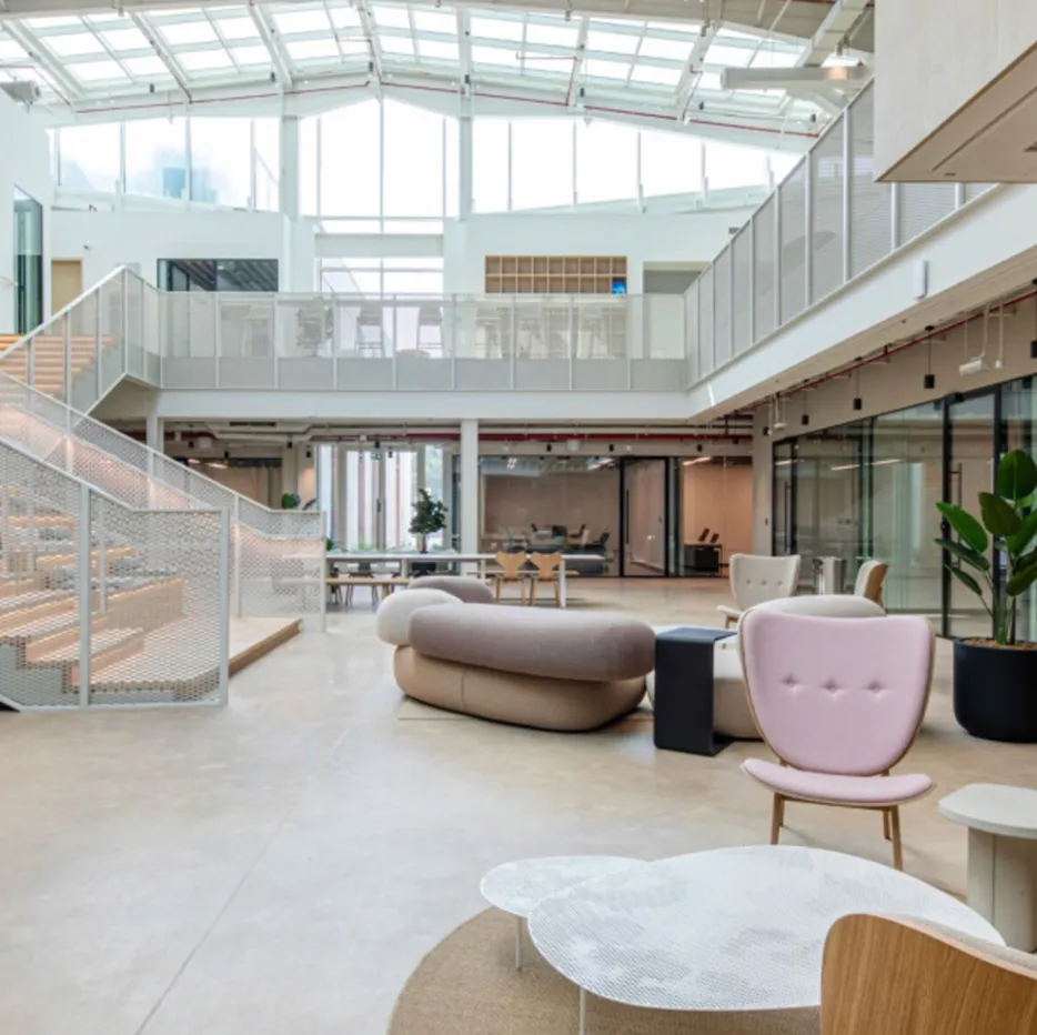 Modern interior design features a staircase with glass panels and metal frames.