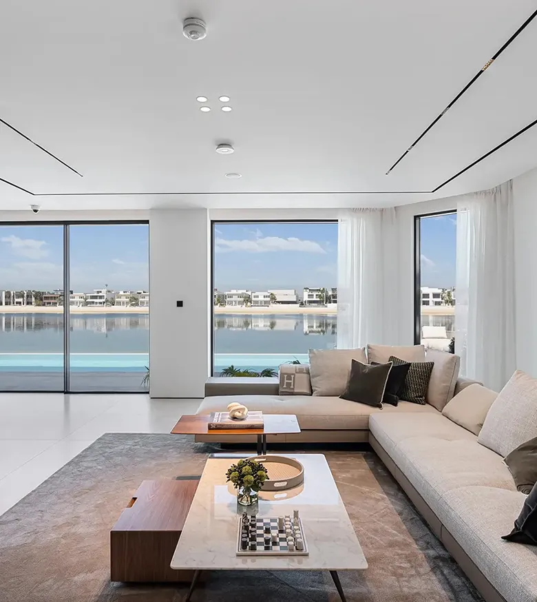 Modern interior design with floor-to-ceiling windows and waterfront view.