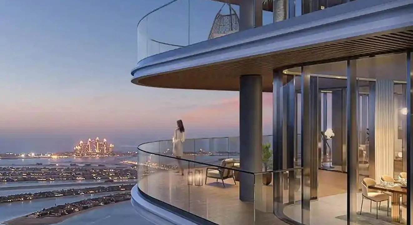 Luxury penthouse balcony with sunset view of Palm Jumeirah and coastline in Dubai.