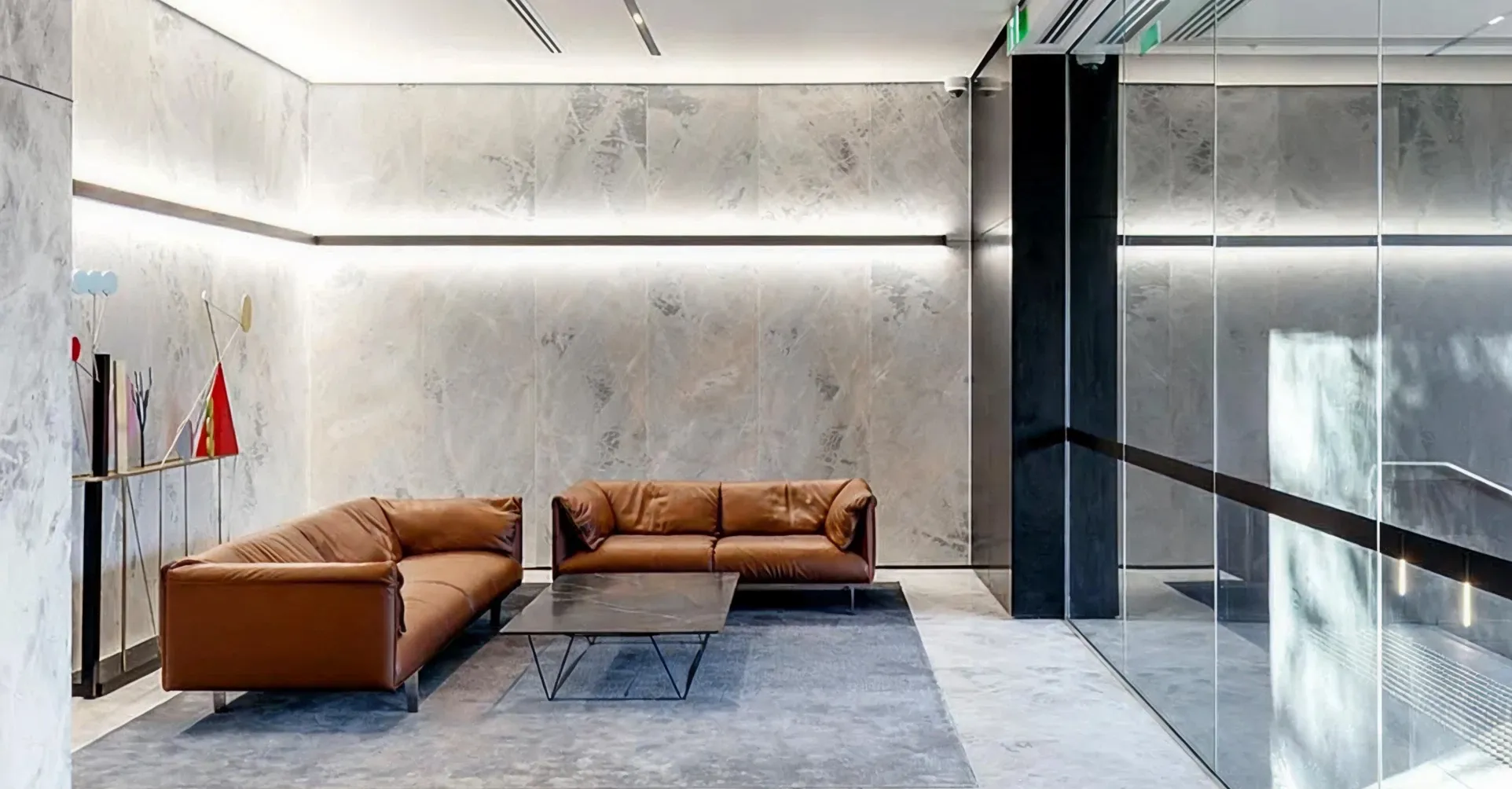 Minimalist office lobby fit out featuring veined grey marble and custom furniture.