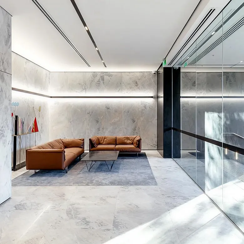 Minimalist office lobby fit out featuring veined grey marble and custom furniture.