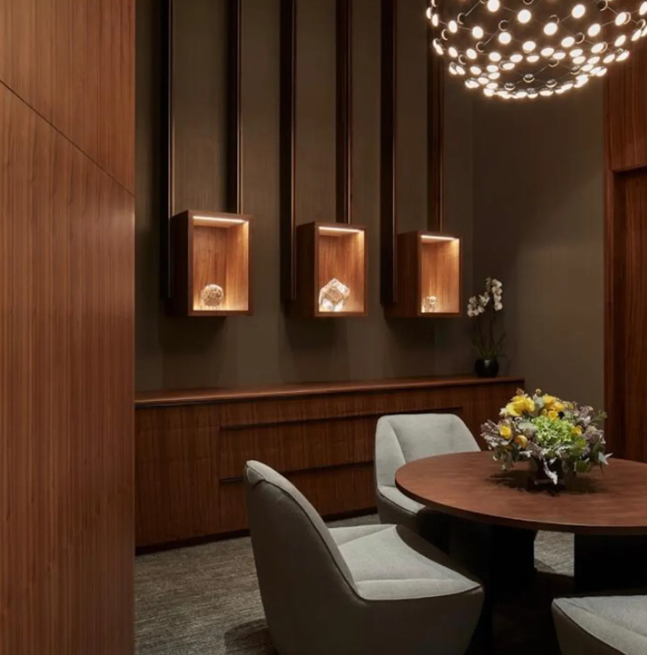 Contemporary meeting room featuring wood-panelled walls and designer lighting.