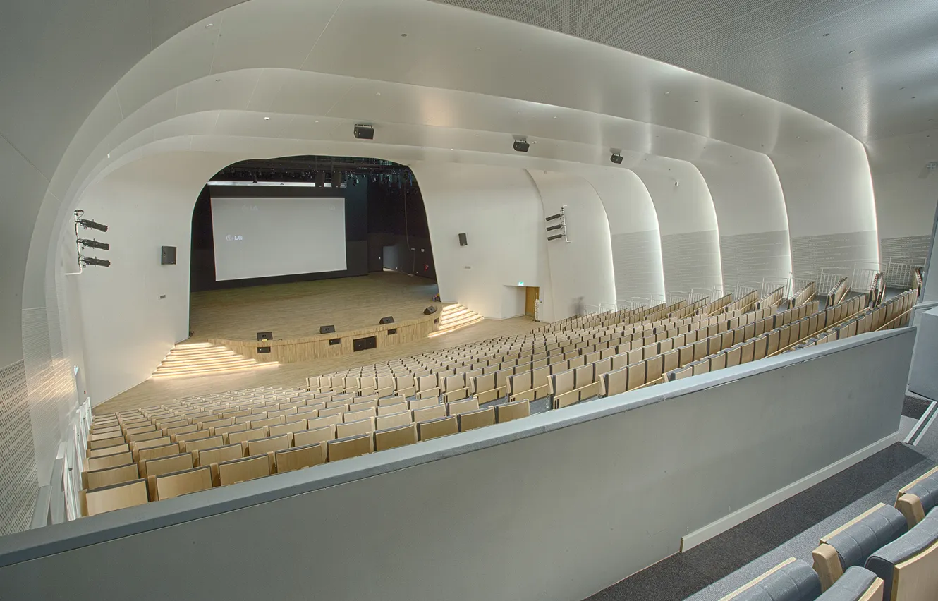 Contemporary auditorium interior design with tiered seating and modern finishes.