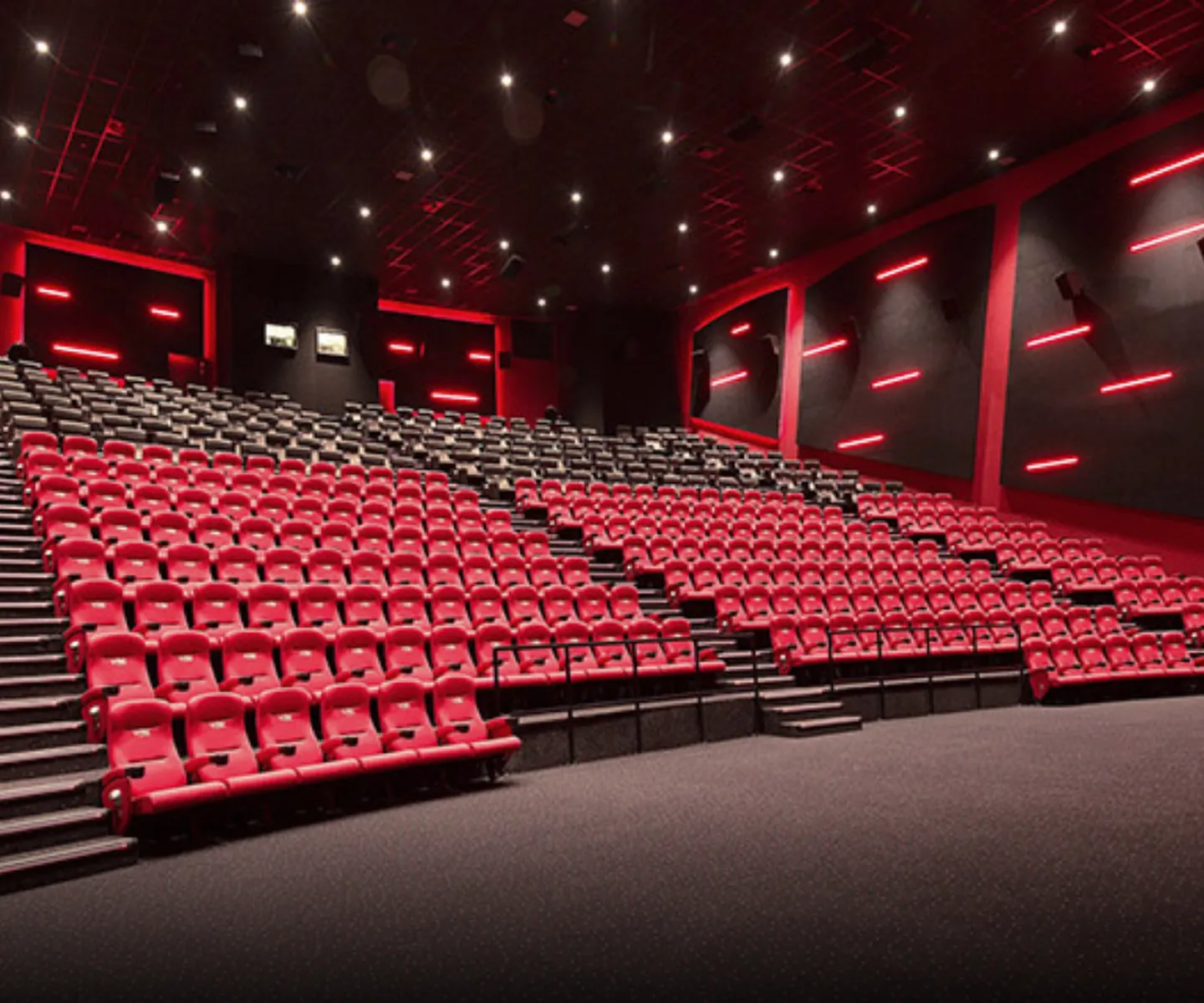 Commercial Interior Design of a modern cinema auditorium with red accent lighting by Rayfitout.