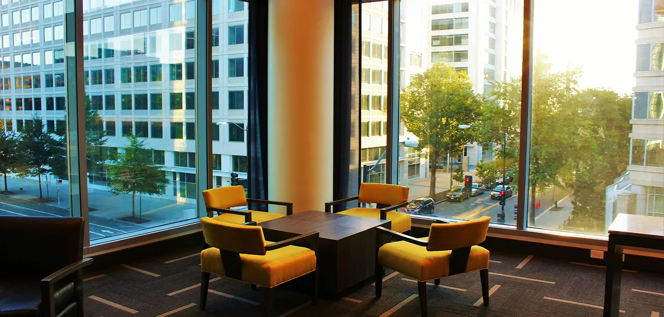 Contemporary office lounge design with bold seating and floor-to-ceiling windows.