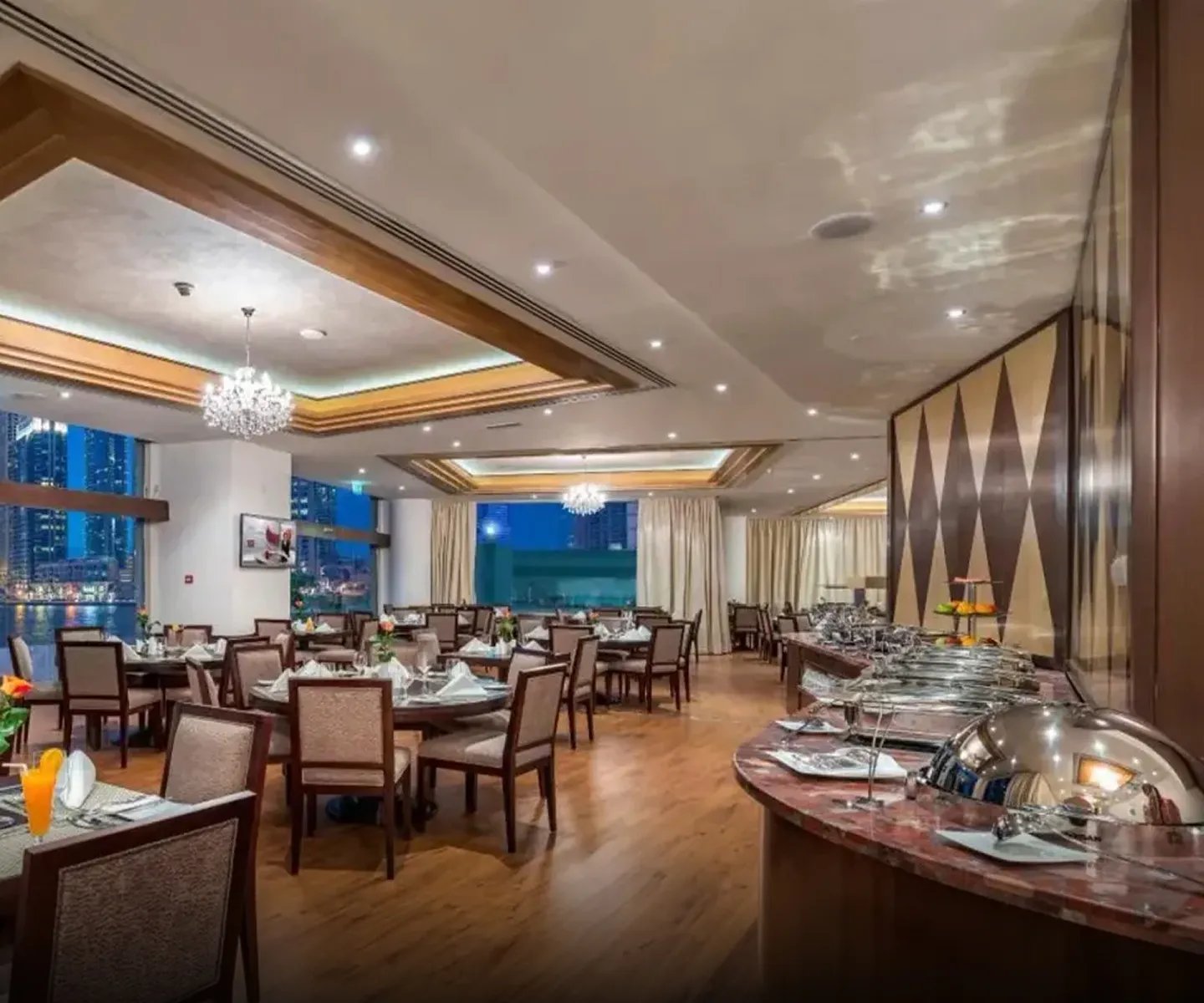 City Premiere Hotel interior featuring buffet station, chandeliers, and wood accents in Dubai.