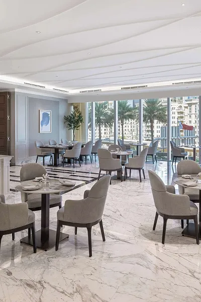 Modern hospitality interior with marble flooring and elegant dining tables in Dubai.