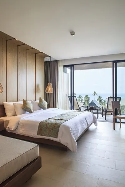 Contemporary hotel room interior featuring floor-to-ceiling windows and natural textures.