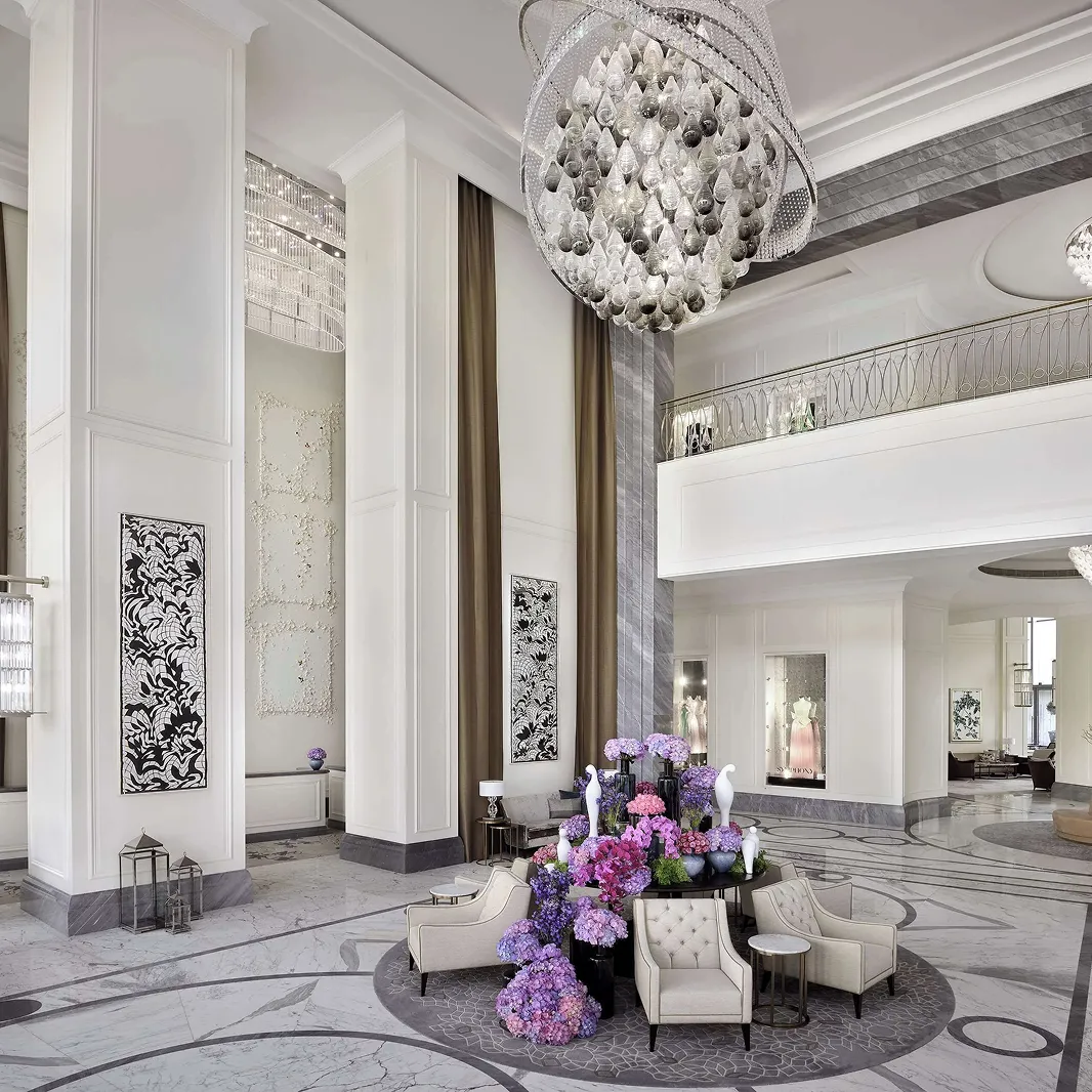 Hospitality Interior Design of a luxury hotel lobby in Dubai with a crystal chandelier and marble floors.