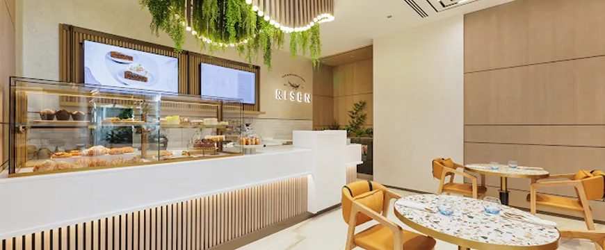 Hospitality Interior Design of a modern cafe with pastry display and custom furniture.