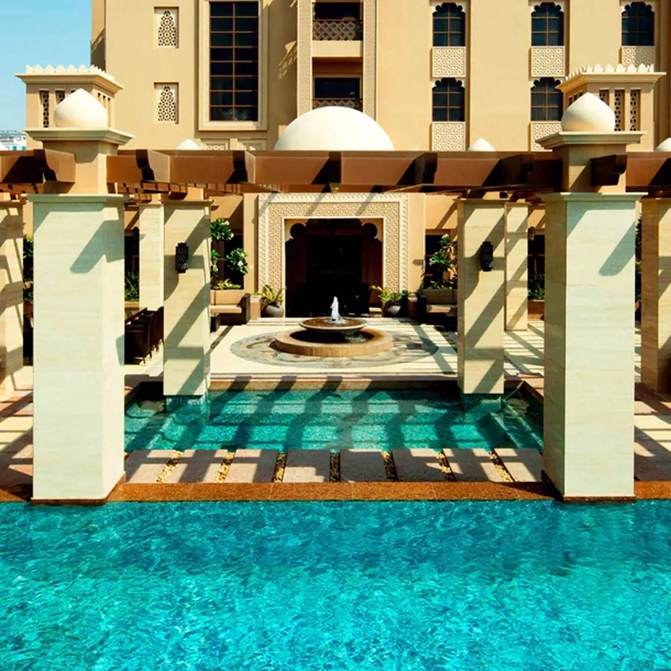 Hospitality interior design of a luxury resort featuring pool and Arabian architecture in Dubai.
