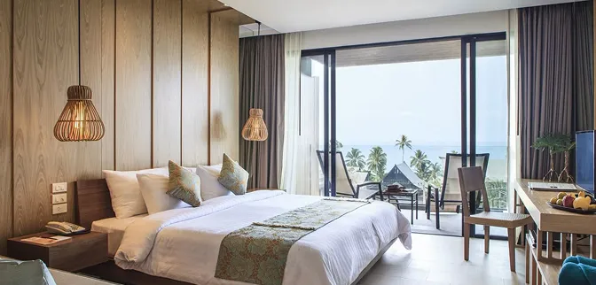 Contemporary hotel room interior featuring floor-to-ceiling windows and natural textures.