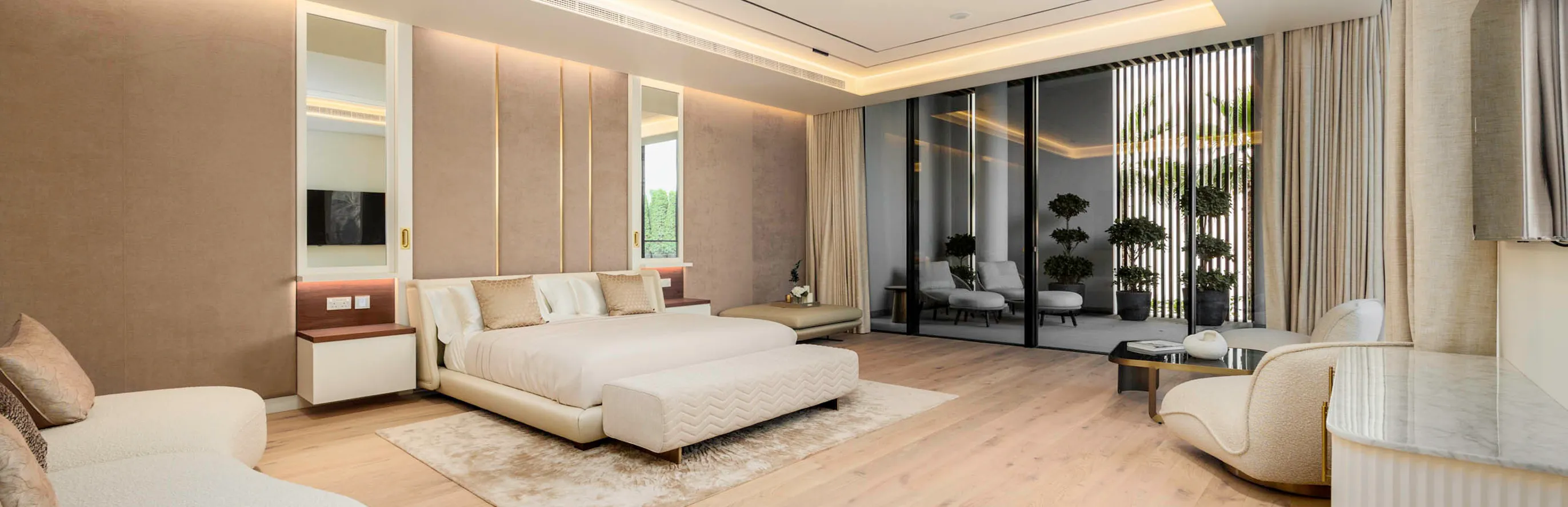 Modern bedroom interior featuring floor-to-ceiling glass doors and indoor-outdoor flow.