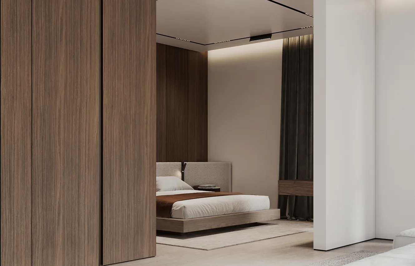 Custom bedroom interior design featuring an upholstered bed and dark wood accent panels by Rayfitout.
