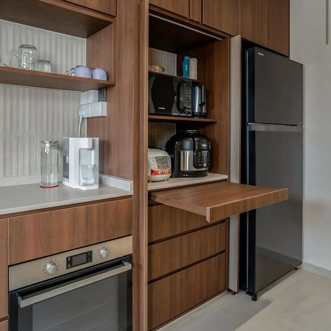Compact kitchen design highlighting smart layout, wood finishes, and stainless steel appliances.