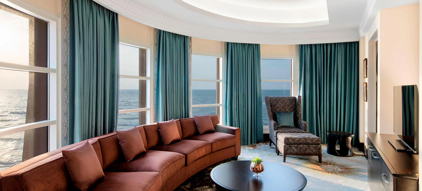 High-end residential interior design of a Palm Jumeirah villa living room with floor-to-ceiling windows.