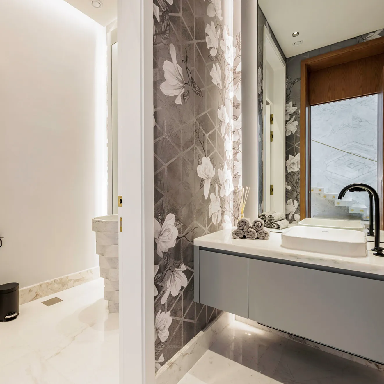 Contemporary bathroom featuring marble floors, accent lighting, and quality hardware.