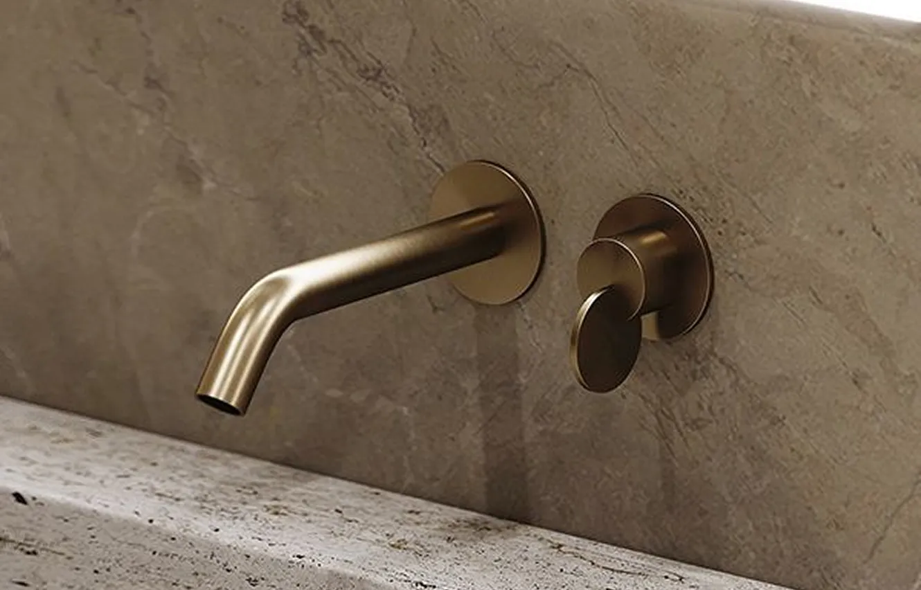Brushed bronze wall faucet installed on a marble bathroom wall in Dubai.