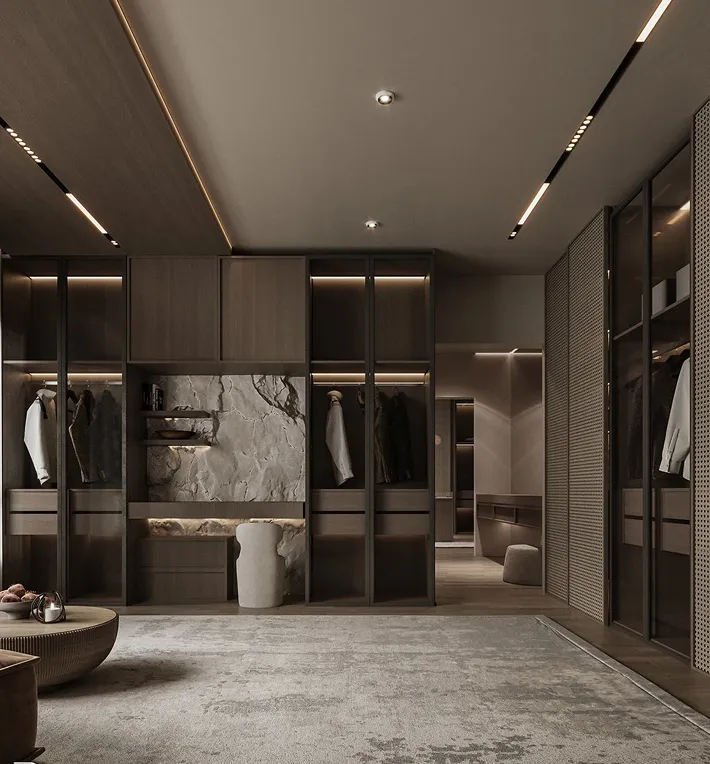 Luxury walk-in wardrobe with dark wood and LED lighting featuring bespoke joinery.