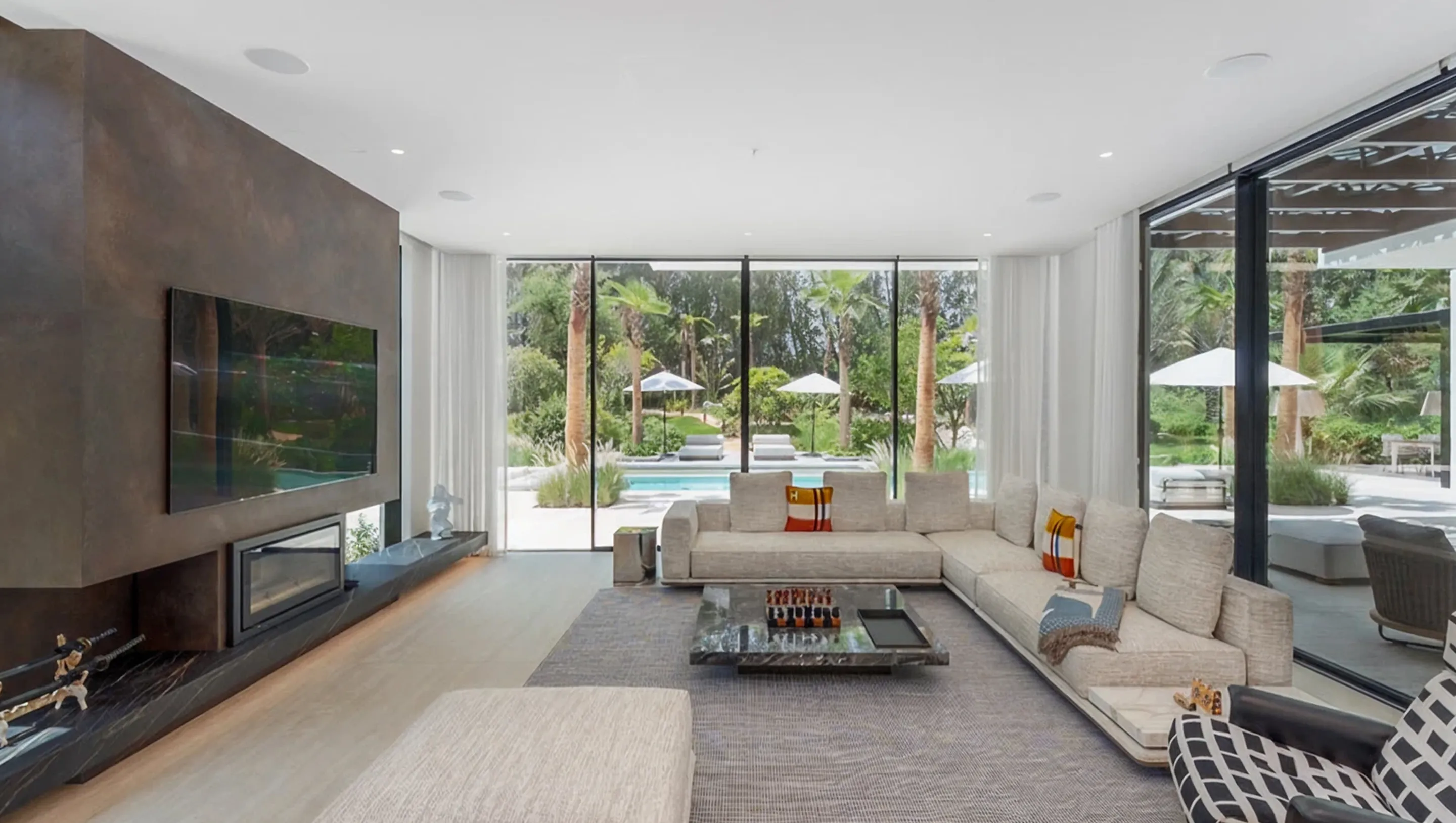 Luxury villa interior design in Dubai featuring floor-to-ceiling windows and modular sofas.