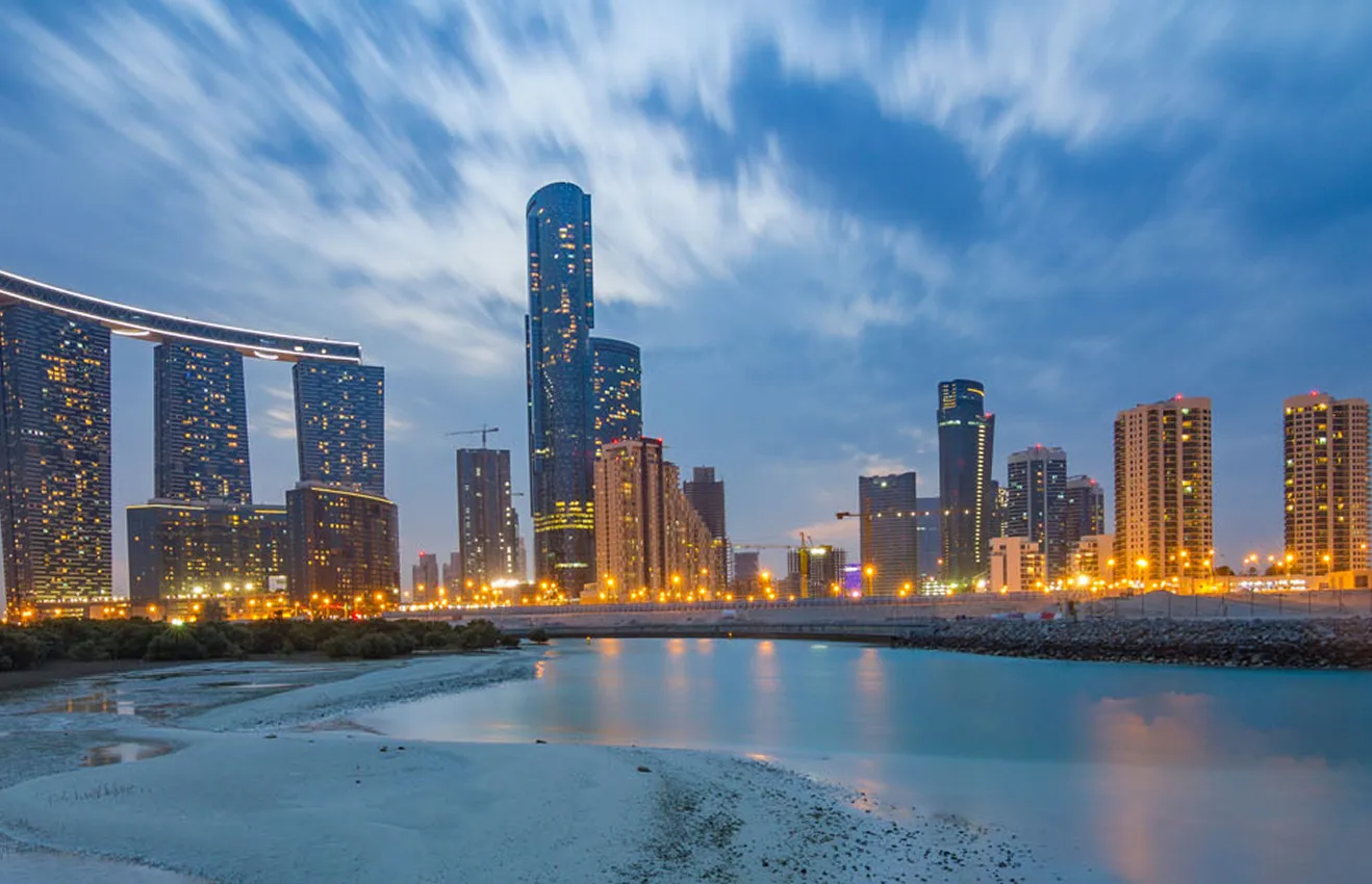 Waterfront villas in Al Reem Island featuring illuminated modern architecture.
