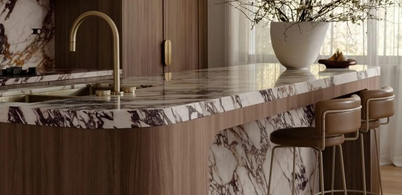 Modern kitchen island featuring a marble countertop and gold fixtures in a private villa.
