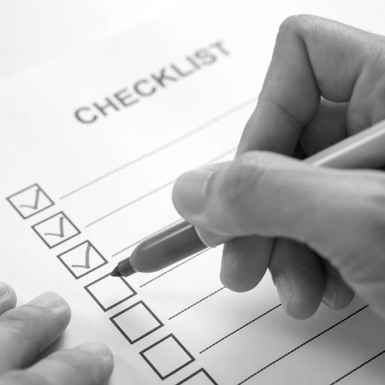 Designer marking completion on an interior design checklist.