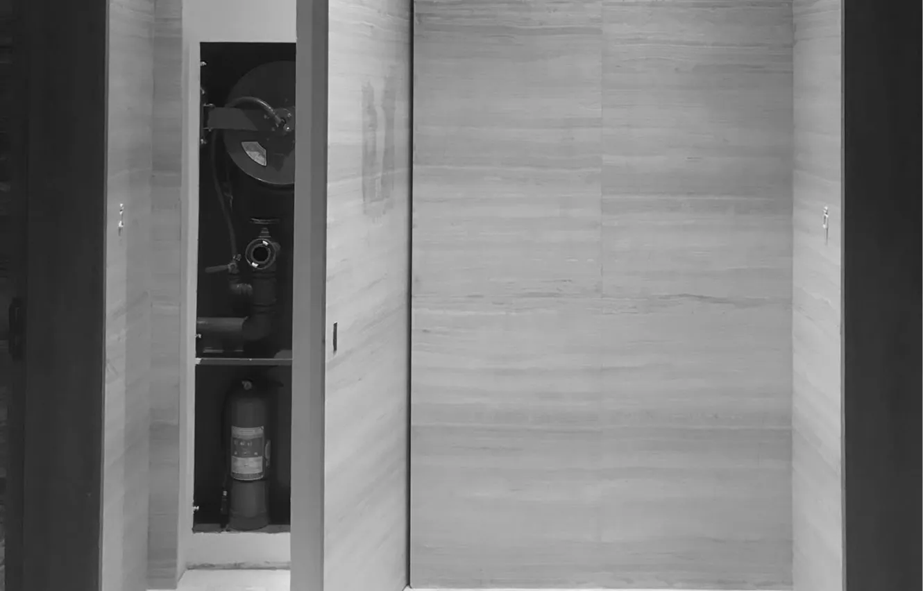 Interior design in a luxury villa featuring a concealed fire safety cabinet.