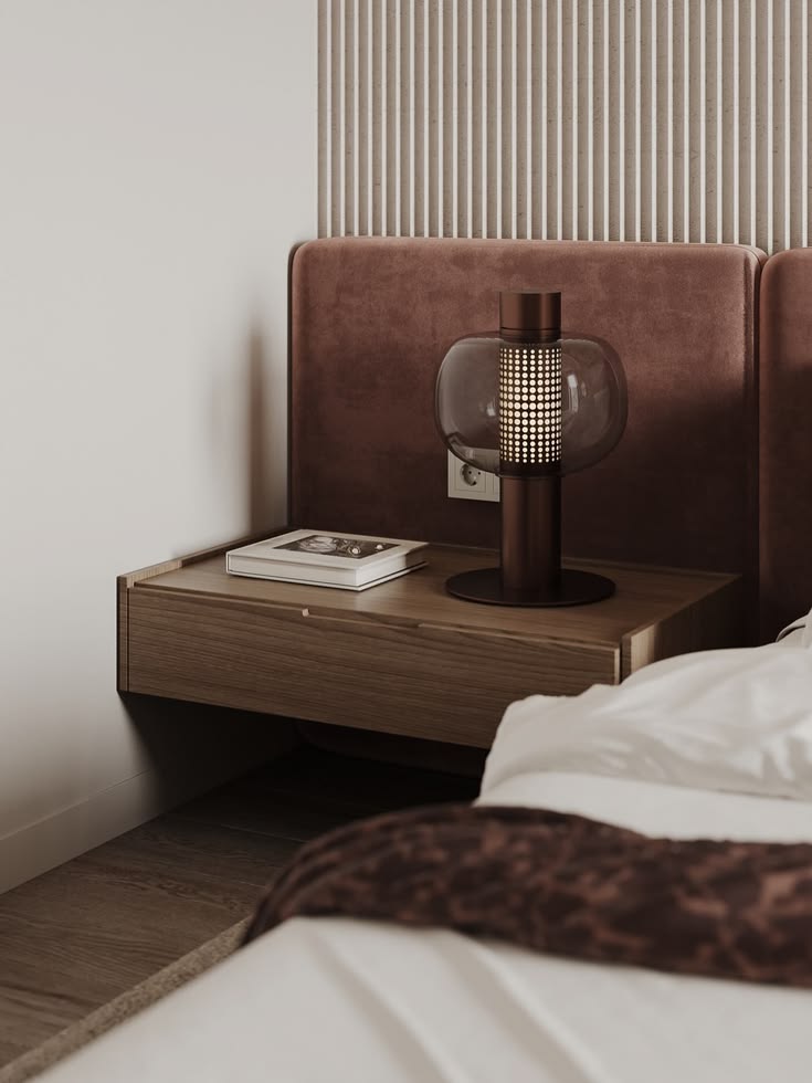 Modern apartment bedroom with wooden bedside table, designer lamp, upholstered headboard, and built-in bedroom layout