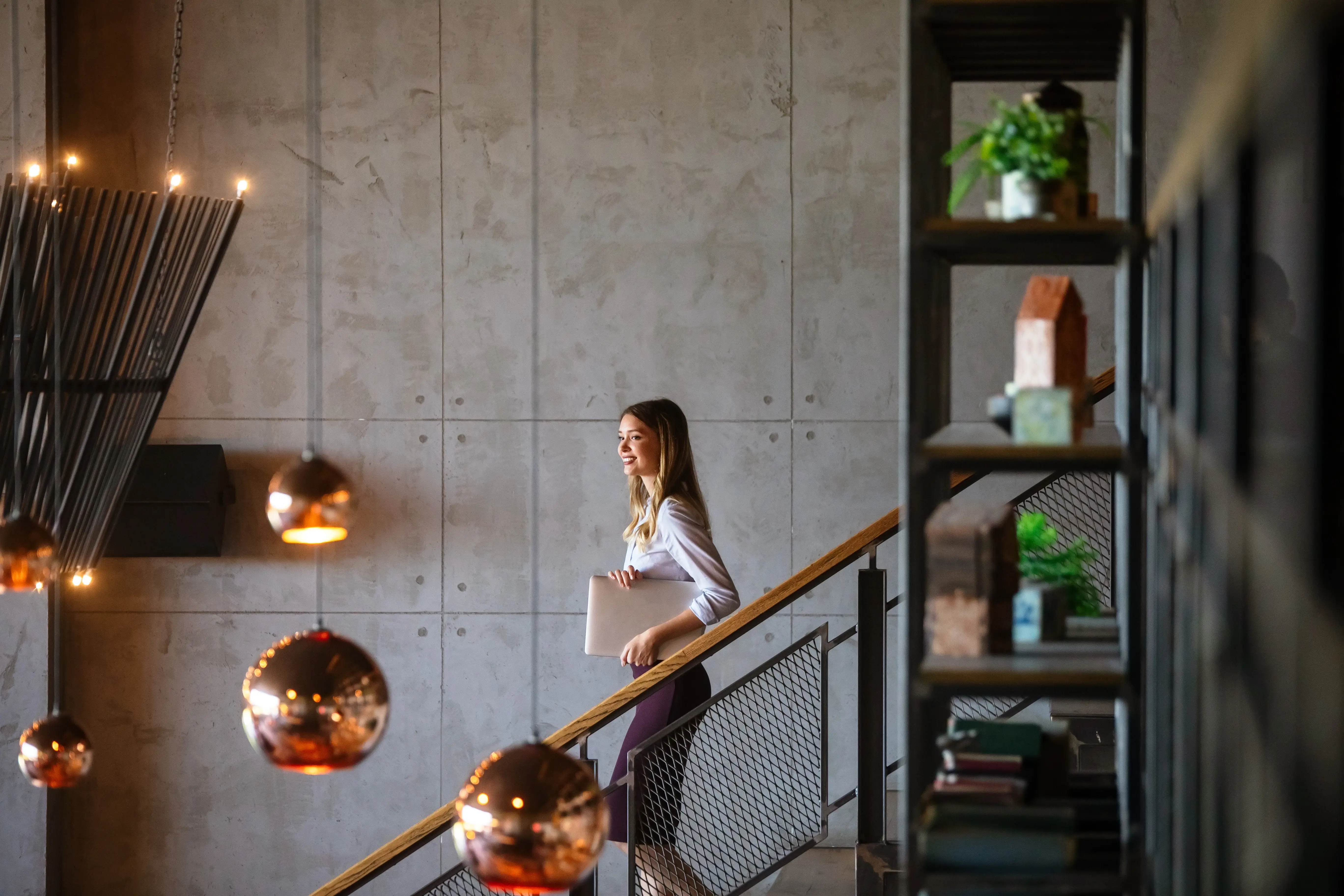 business woman going down the stairs holding a file about Innovative Trends in Architectural Interior Design