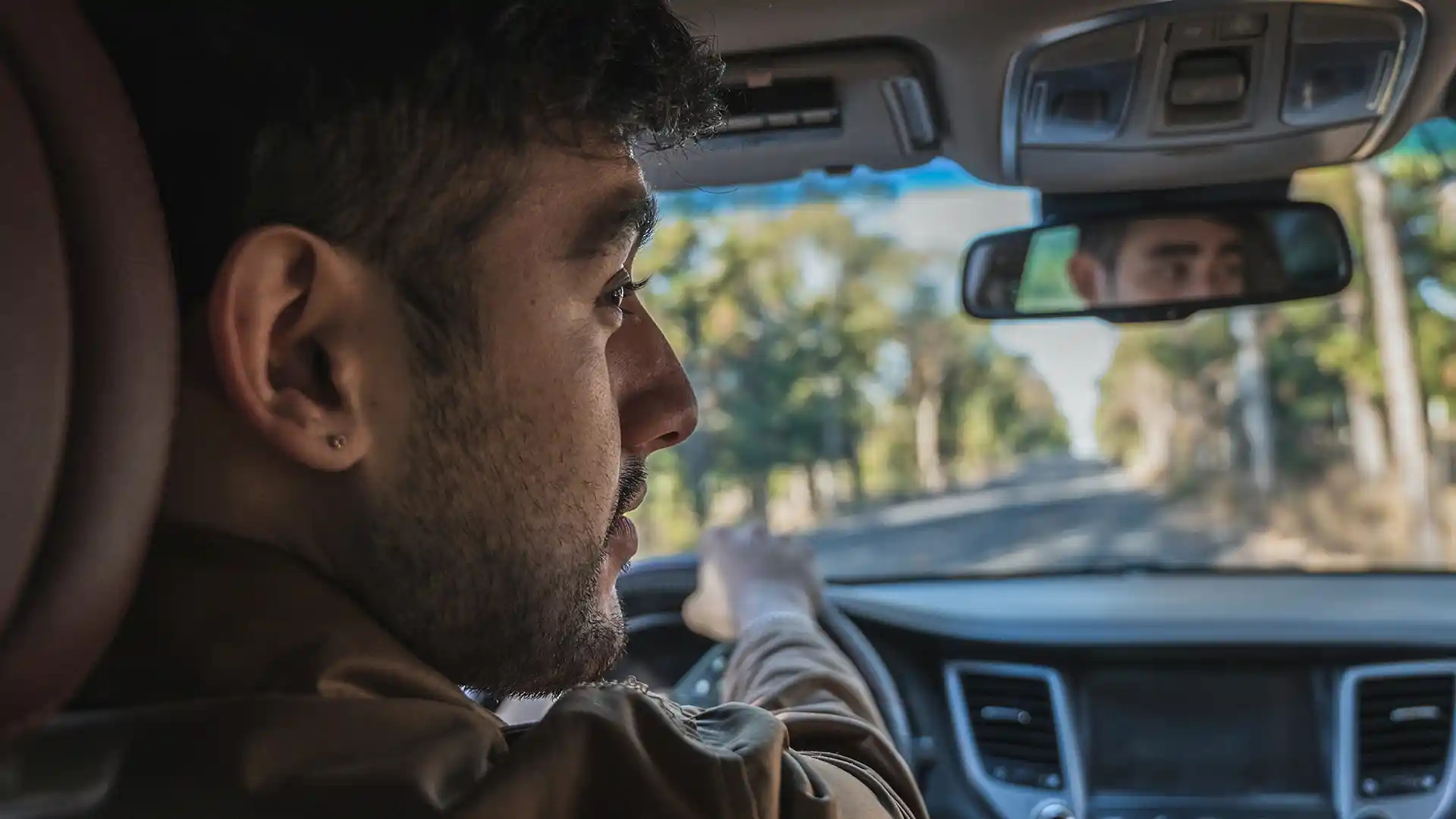 Man driving looking at right mirror