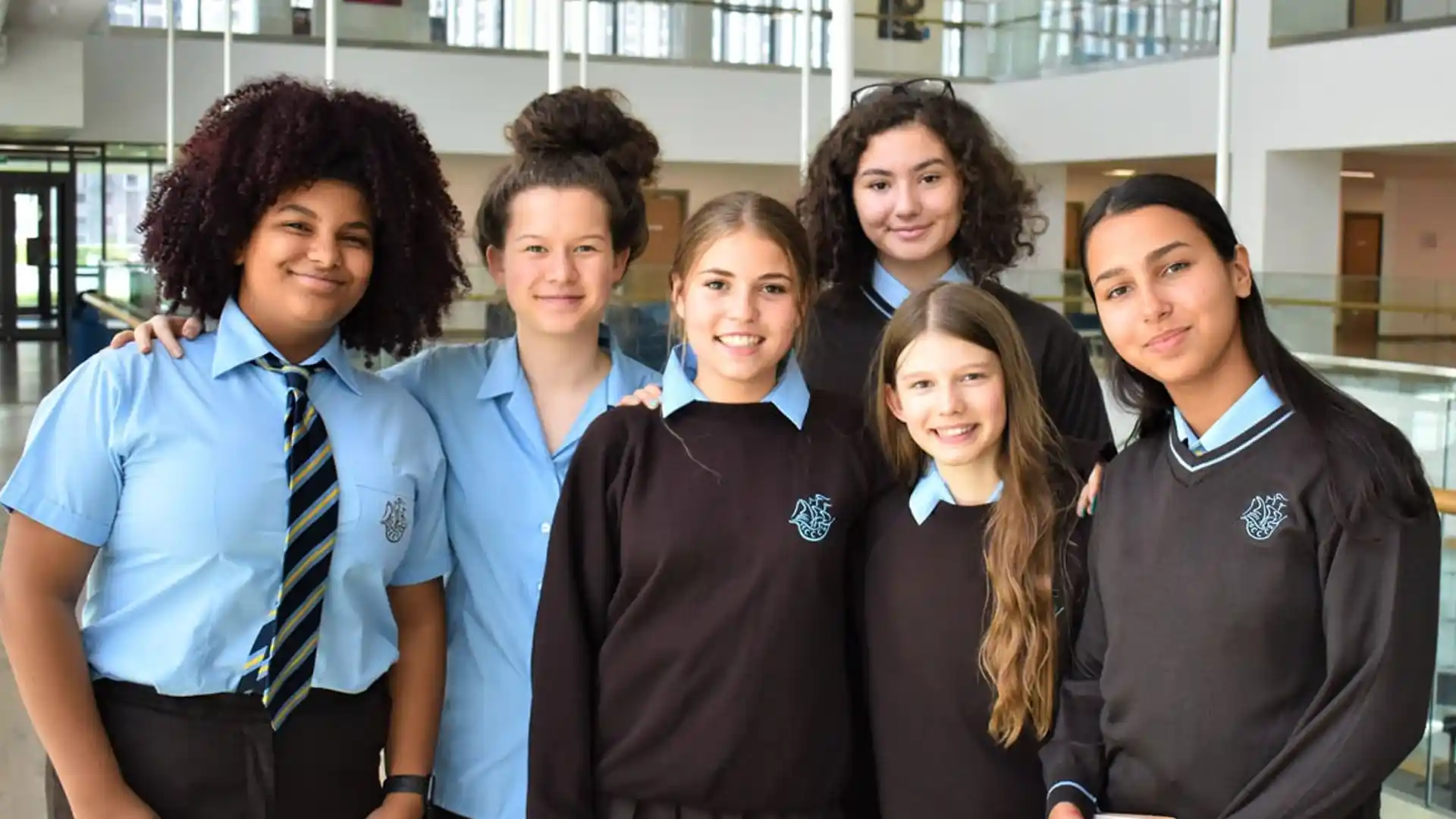 Students in uniform standing inside a modern school building in Dubai, showcasing academic environment and facilities.