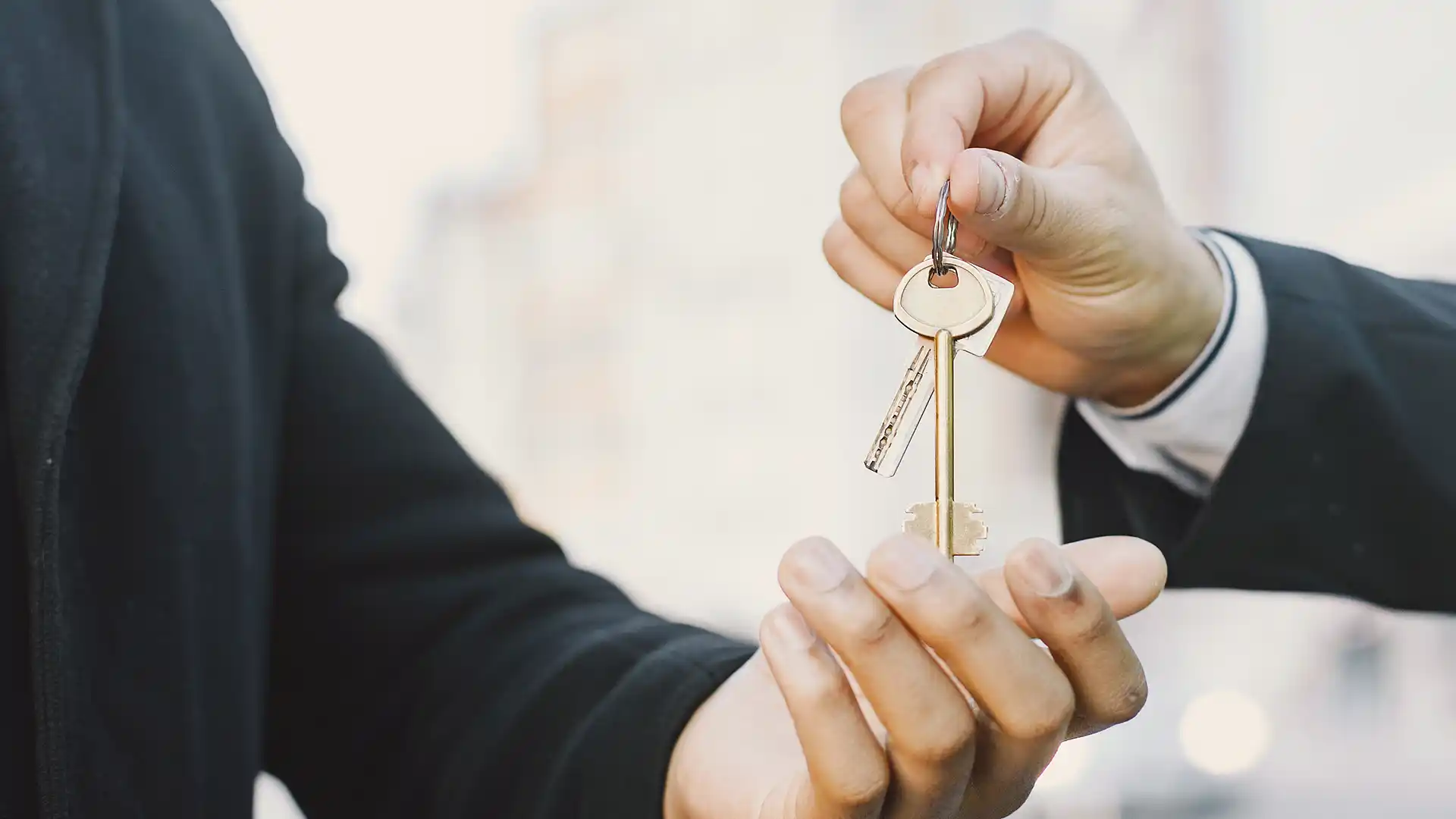 Indian professionals exchanging keys in Dubai, symbolizing successful business ownership and property acquisition