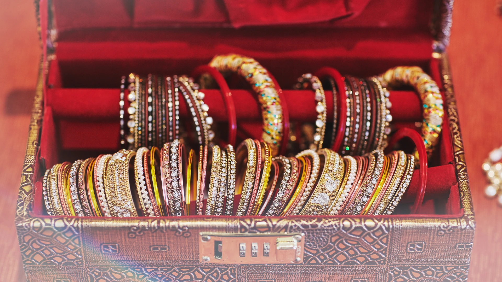 Ornate jewelry box with colorful traditional bangles arranged on red velvet lining for secure storage