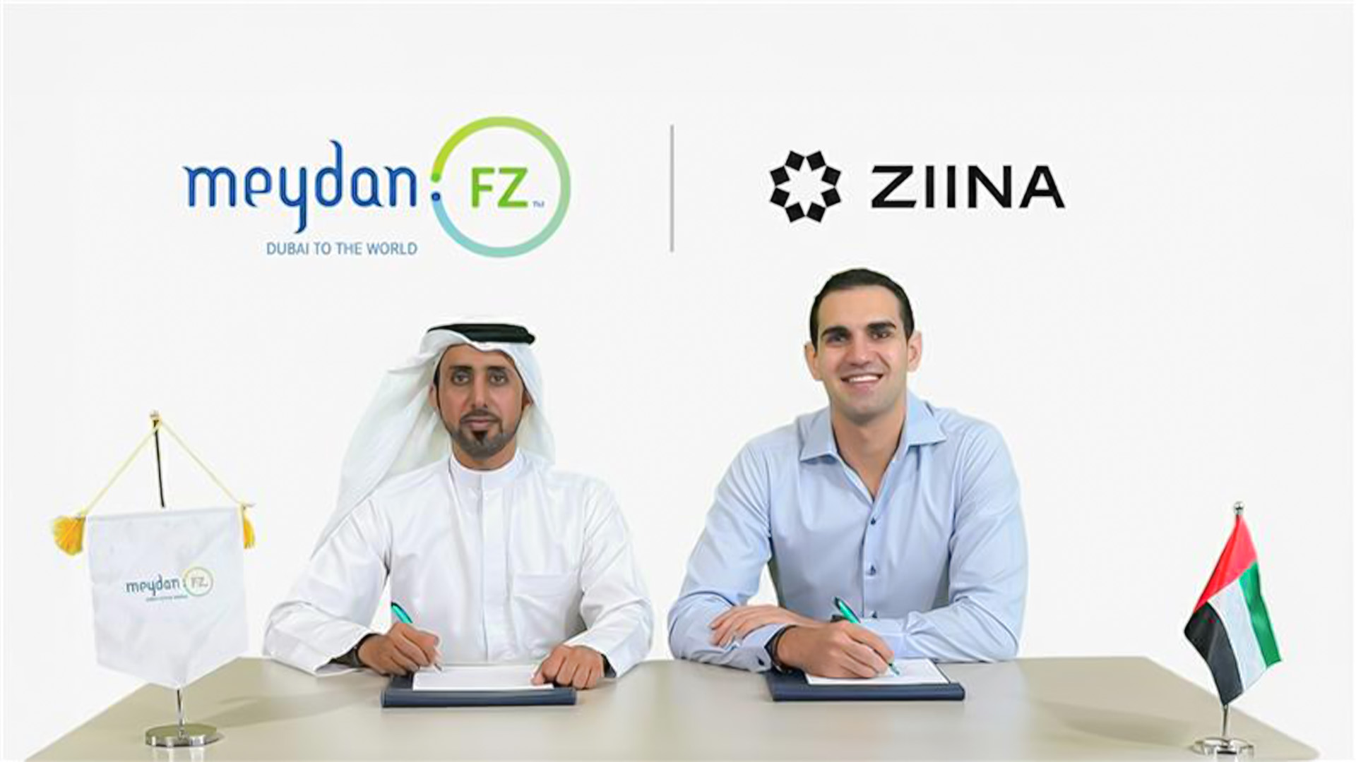2 men signing a contract: Meydan Free Zone x Ziina Partnership