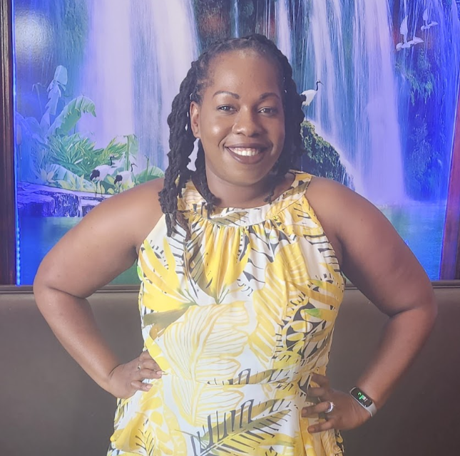 Ms. Robinson smiling in a yellow floral dress