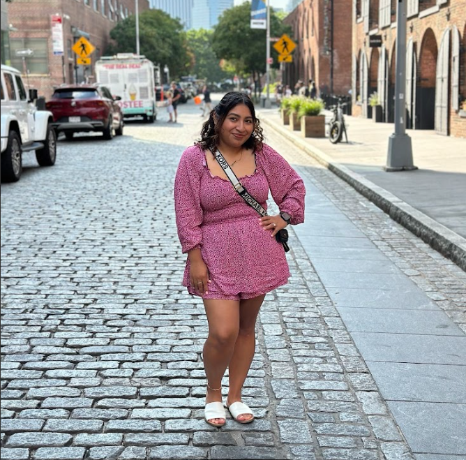 Ms. Velazquez smiling on a cobblestone city street