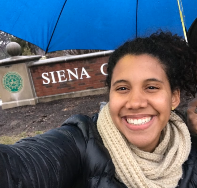 Mrs. Harris smiling in front of Siena College sign