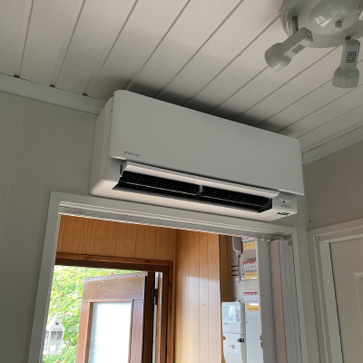 Daikin-ilmalämpöpumpun valkoinen sisäyksikkö oven yläpuolella