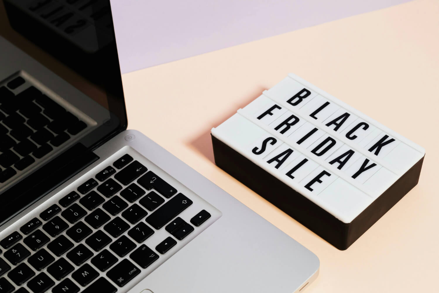 Laptop neben Leuchtbox mit der Aufschrift „Black Friday Sale“ – symbolisiert E-Commerce-Vorbereitungen für das umsatzstärkste Shopping-Event des Jahres.