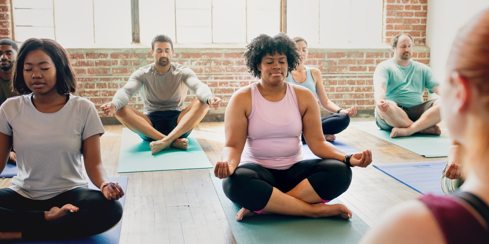 Yoga Classes with diverse people seated in lotus as if meditating