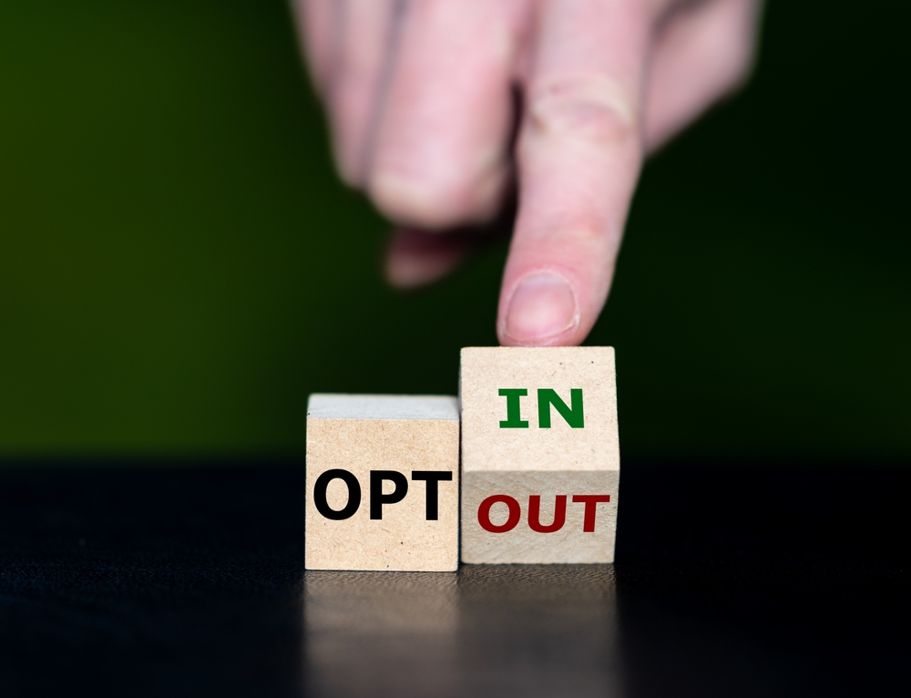 Blocks for OPT In/Out ahand with a finger holding the In/Out block on its corner as if deciding