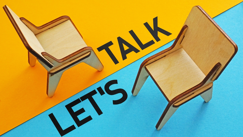 To chairs faing each other offset each on a background of blue or yellow with the words, "Let's Talk"